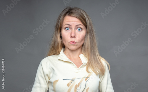 Woman emotion. Surprised woman. Girl with big rounded eyes. Astonishment caused by extremely extraordinary news. Front view, full face. Portrait of woman over gray background shooting in studio