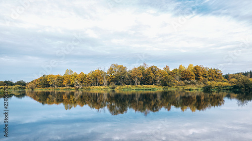 Scenic autumn river with trees on the shore.