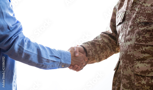 Military and civilian shaking hands standing on white background