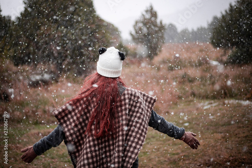 happy girl surrounded by snowflakes in nature