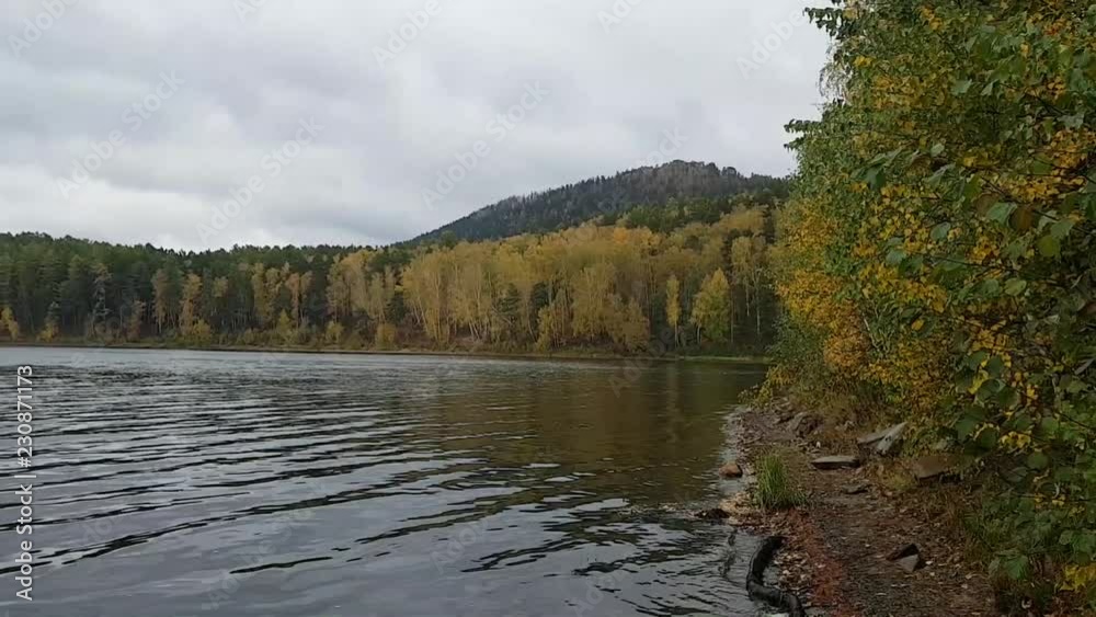 Lake Arakul in the Chelyabinsk region in the autumn day. Beautiful colorful foliage of trees and reflection on the water Lake Arakul in the Chelyabinsk region in the autumn day. Beautiful colorful foliage of trees and reflection on the water