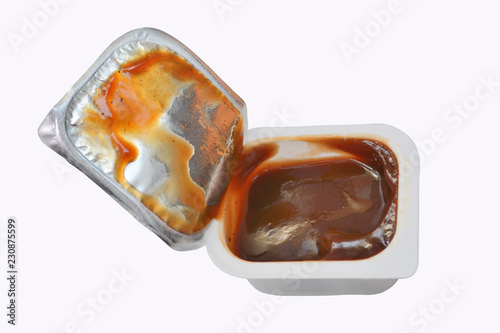 open plastic container with sauce ketchup or a barbecue isolated on a white background