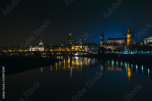 View of the old town of Dresden at night with a view of water and the reflection of the city as well as, churches, towers and buildings. Elbe river. Germany. Saxony.
