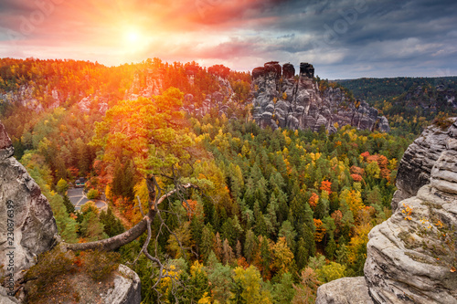 Amazing autumn landscape in Saxony Bastei Mountains national park. View Exposed sandstone rocks and forest hilly at sunset. Concept of outdoor recreation in natural settings out of town. 