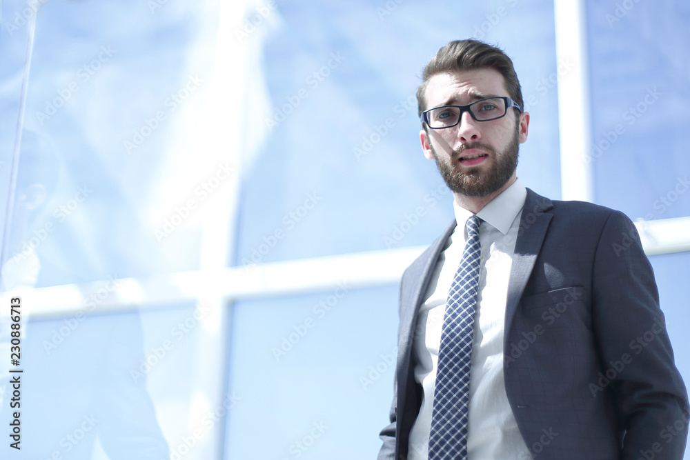 young businessman standing near the office window young businessman standing near the office window
