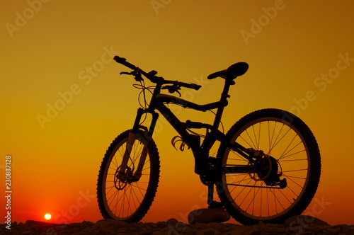 Silhouette of mountain bicycle against sunset sky