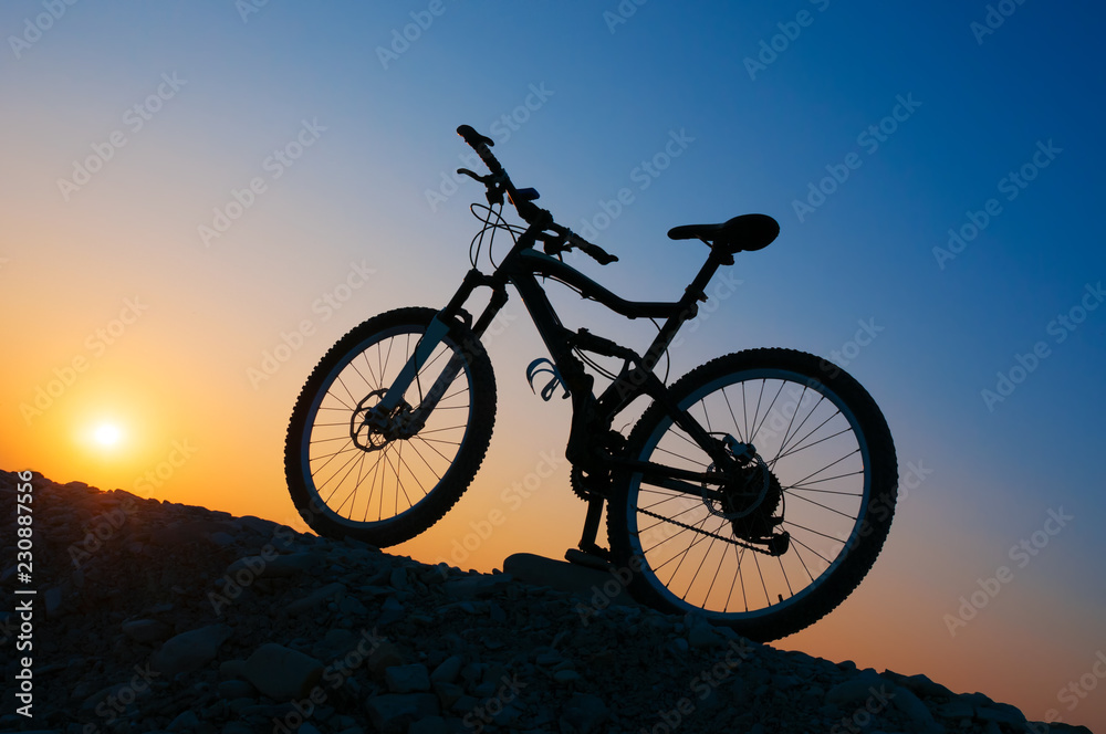 Obraz premium Silhouette of mountain bicycle at sunset