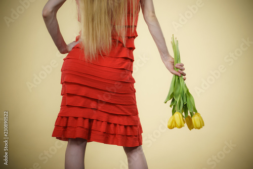 woman with yellow tulips bunch, back view