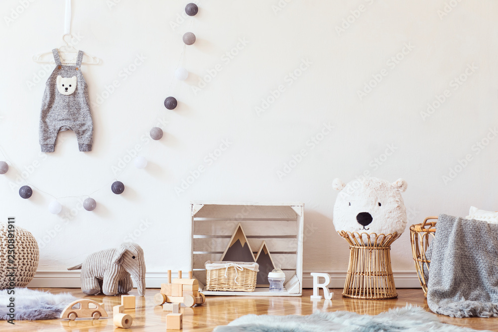 Stylish scandinavian child room with mock up photo poster frame on the  pattern wall, boxes, teddy bear and toys.Cute modern interior of playroom  with white walls, wooden accessories and colorful toys. Photos