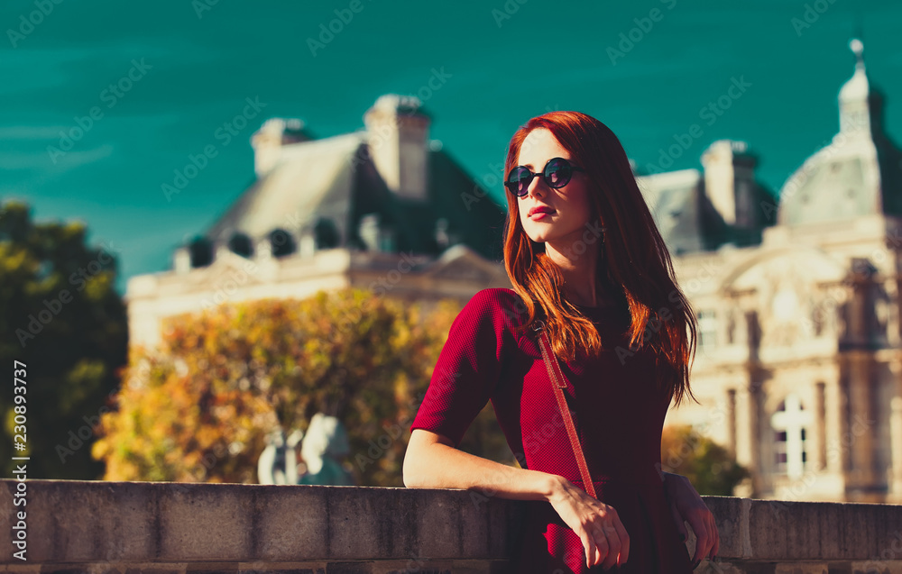 style redhead girl in glasses near Luxembourg Palace in Paris