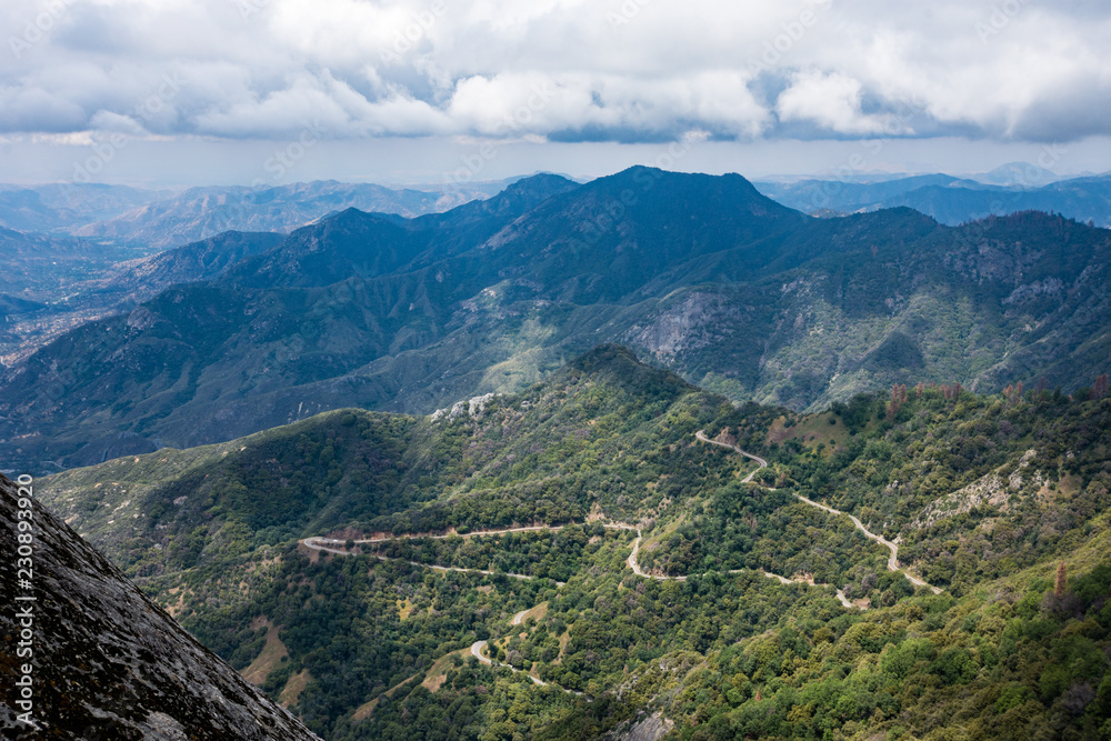 View of the valley in Sequoia National Park in California from the Moro Rock summit hiking trail.  Winding twisty mountain road below