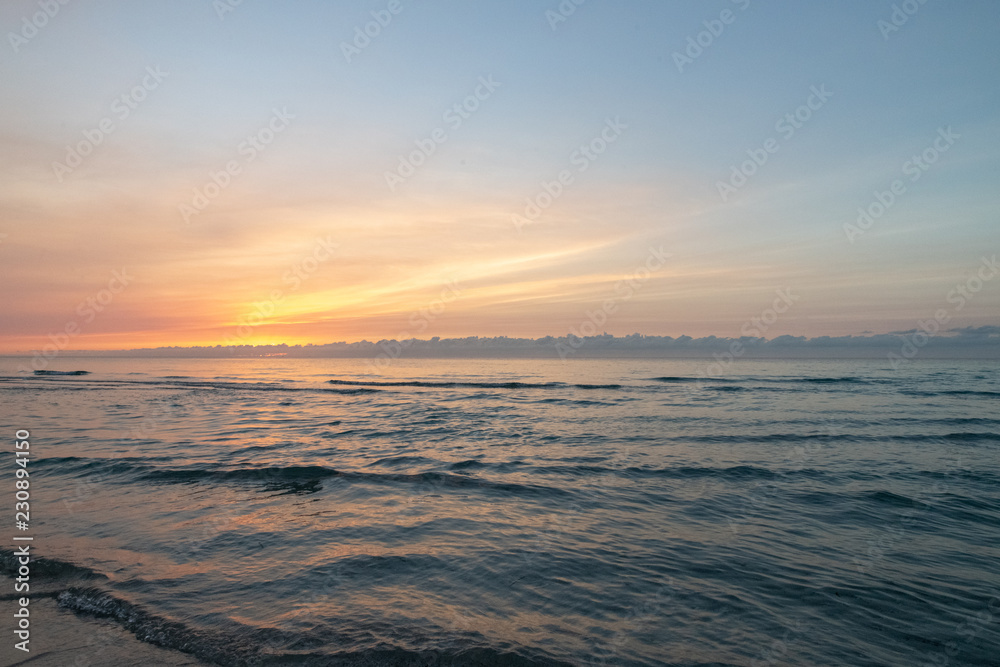 waves on the beach in the ocean at sunset