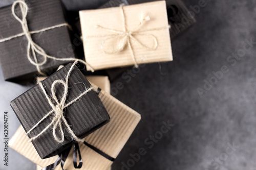 Black and brown gift boxes for holidays gift on dark texture background.