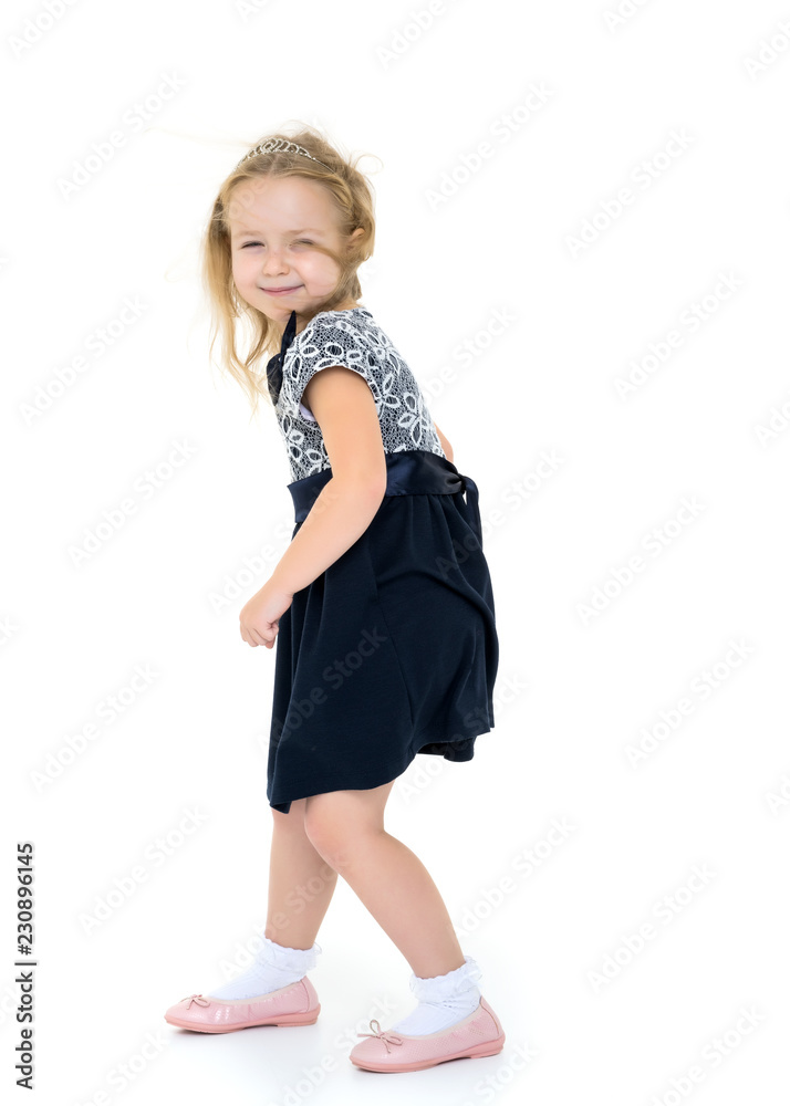 Fototapeta premium Little girl in a dress developing in the wind.