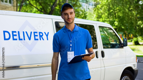 Obraz na plátně Delivery company worker filling report, student part-time job, fast shipment
