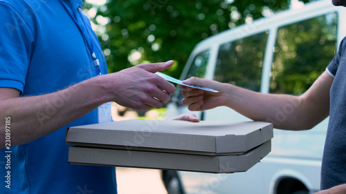 Fotografie Deliveryman receiving money for pizza shipment, food delivery, part-time job