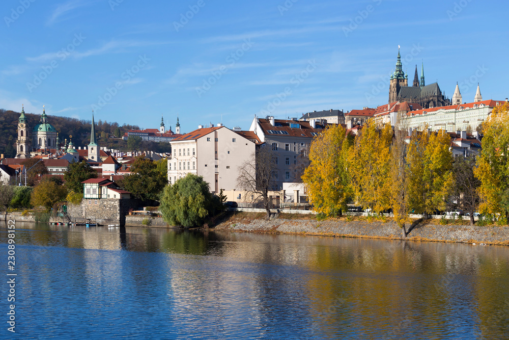 Fototapeta premium Colorful autumn Prague gothic Castle with the Lesser Town above River Vltava in the sunny Day, Czech Republic