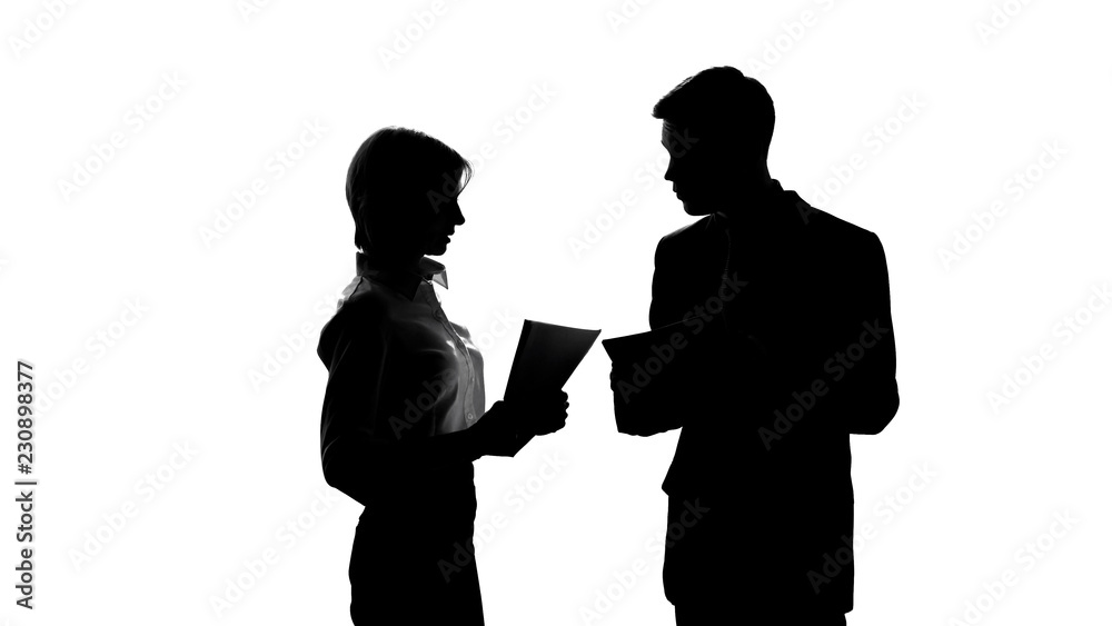 Silhouette of male boss jawing his secretary because of mistakes in report Silhouette of male boss jawing his secretary because of mistakes in report