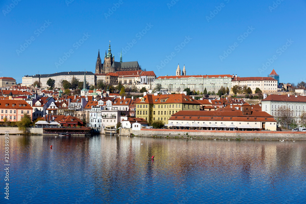 Naklejka premium Colorful autumn Prague gothic Castle with the Lesser Town above River Vltava in the sunny Day, Czech Republic