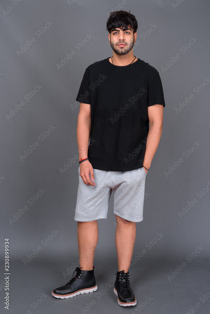 Young handsome Indian man against gray background Young handsome Indian man against gray background