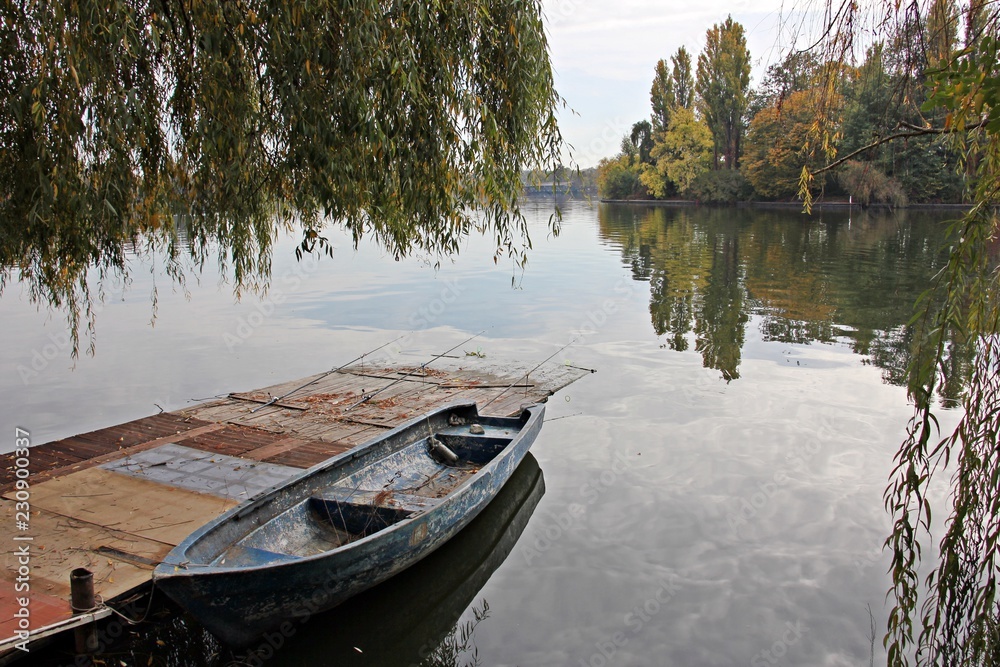 Wooden boat on the bank of lake  during fall season