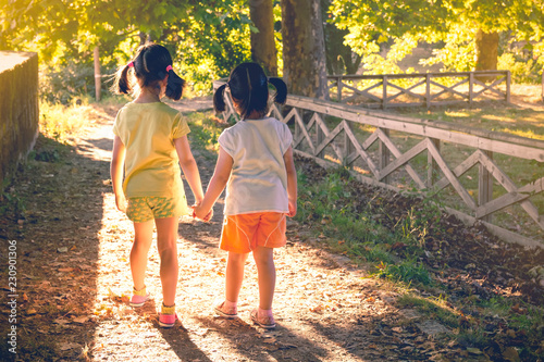 Anonymous girls holding hands in park