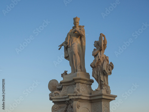 Baroque sand stone Statue Saint on Charles Bridge in Prague  Czech Republic  sunny day  clear blue sky