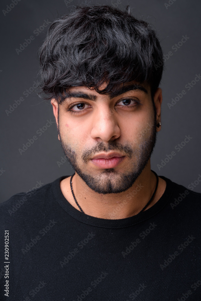 Young handsome Indian man against gray background Young handsome Indian man against gray background