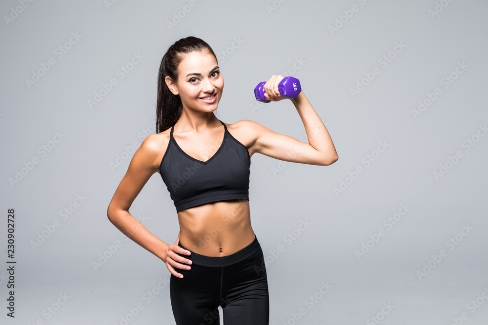 Portrait of a pretty young sportswoman doing exercises with dumbbells isolated on a white background Portrait of a pretty young sportswoman doing exercises with dumbbells isolated on a white background