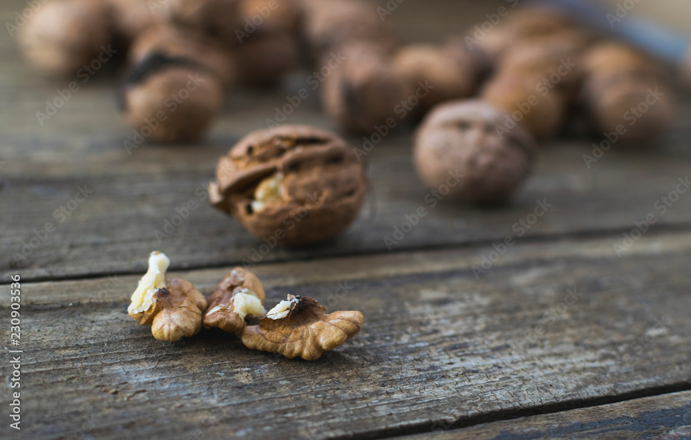 Whole and chopped walnuts on wooden table Whole and chopped walnuts on wooden table