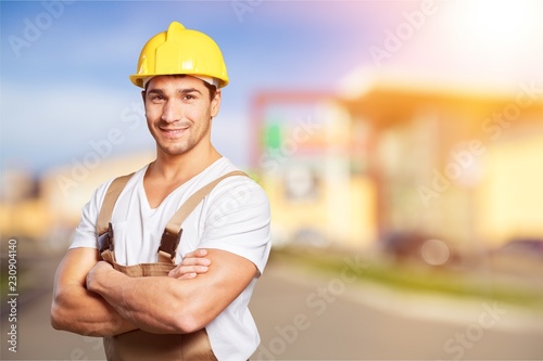 Young builder in hardhat on blurred construction materials store