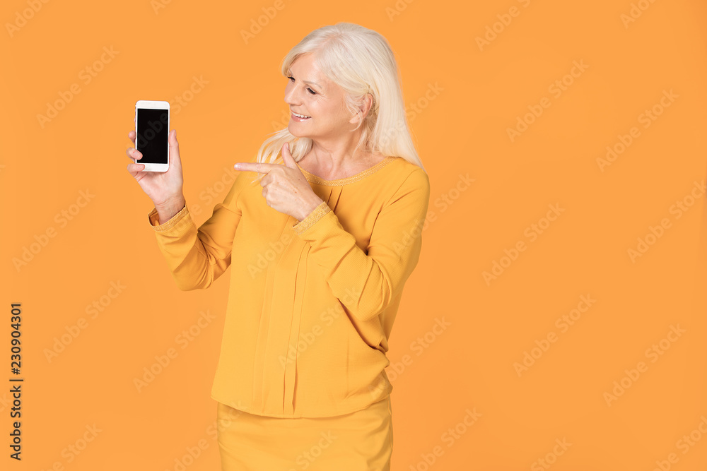 Senior woman posing with mobile phone.