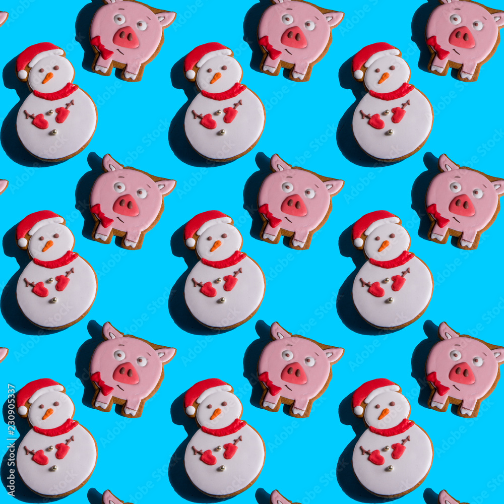 Seamless background with gingerbread in the form of pig and snowman on a vivid blue background. Hard shadows. Abstract art christmas background. Minimal print concept. Flat lay food Seamless background with gingerbread in the form of pig and snowman on a vivid blue background. Hard shadows. Abstract art christmas background. Minimal print concept. Flat lay food