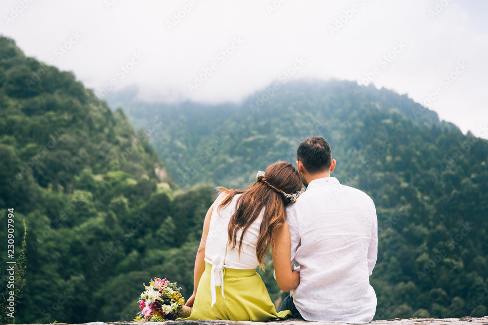 Young woman lying on her boyfriend's shoulder on a forest view