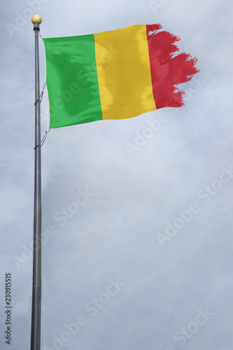 Worn and tattered Mali flag blowing in the wind on a cloudy day
