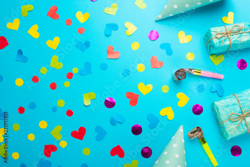 Festive frame or bright background, gift, confetti, carnival hat and streamer. Flat style. Birthday or holiday card with a copy.