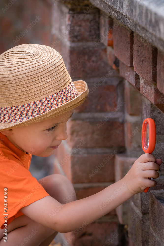 Little boy with magnifying glass looking for clues