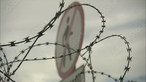 No Entry Sign with Barbed Wire and Razor Wire Security or Border Fence
