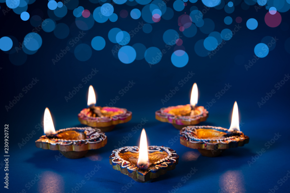 Happy Diwali - Clay Diya lamps lit during Dipavali, Hindu festival of lights celebration - obrazy, fototapety, plakaty 