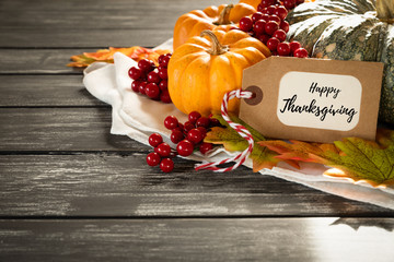 Autumn maple leaves with Pumpkin and red berries on old wooden backgound. Thanksgiving day concept.