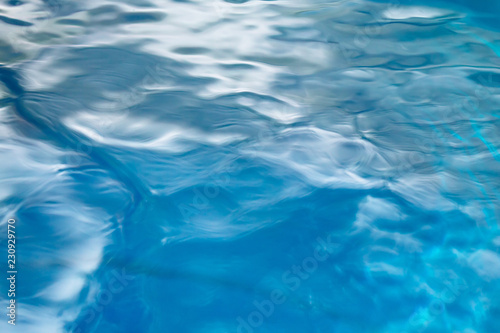 The smooth natural blue water background with bokeh abstract on the sea or ocean,vintage and soft colored blur.