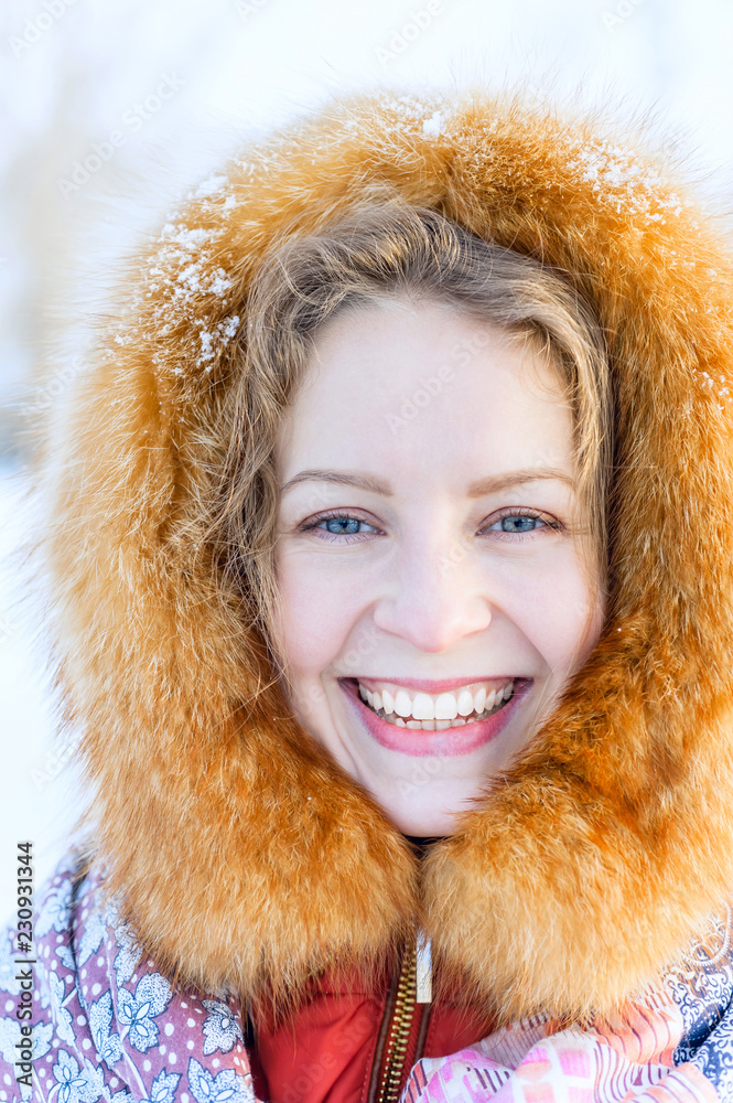 Beautiful Russian woman in a fur hood and woolen mittens. Outdoor fashion winter portrait. Beautiful Russian woman in a fur hood and woolen mittens. Outdoor fashion winter portrait.