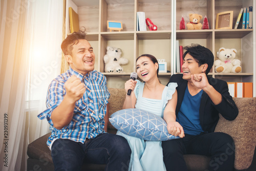 Group of friends having fun at living room singing a song together