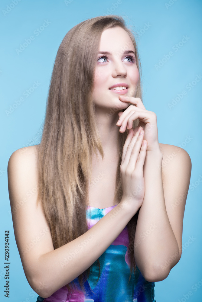 Beautiful young girl on the blue background look up Beautiful young girl on the blue background look up