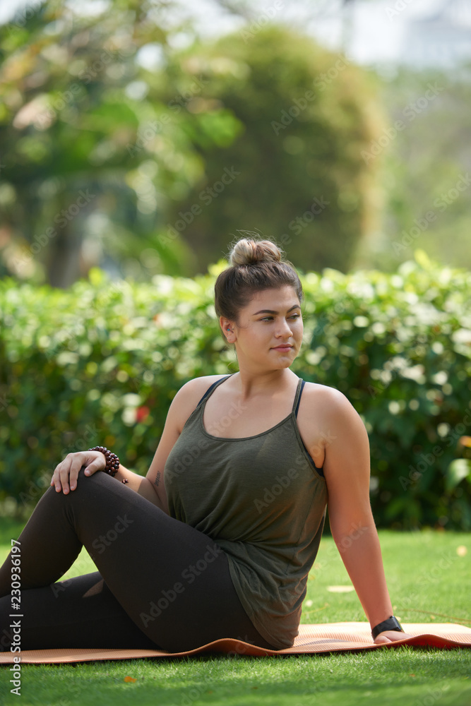 Plus size woman practicing yoga in city park Plus size woman practicing yoga in city park