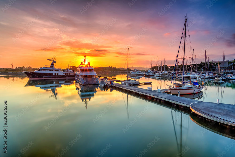 A majestic sunrise with boat resting near   the dock as foreground at Putri Harbour, Iskandar Malaysia.