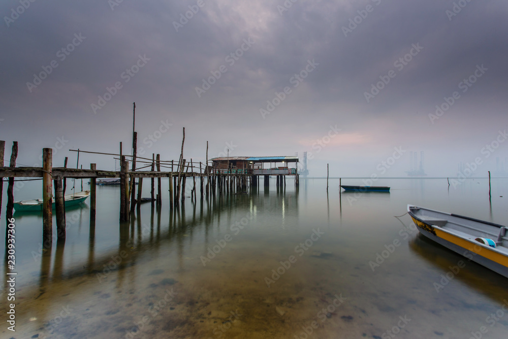 Cloudy long exposure sunrise shot at jetty. Image contain certain grain or noise and soft focus when view at full resolution