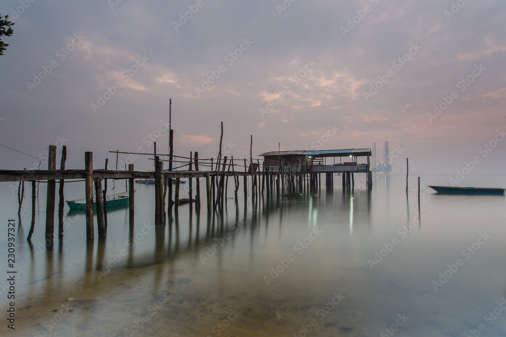 Cloudy long exposure sunrise shot at jetty. Image contain certain grain or noise and soft focus when view at full resolution