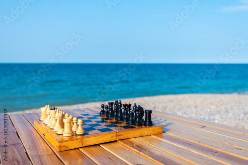 Fototapeta Naklejka Na Ścianę i Meble -  Chess board on the table by the sea