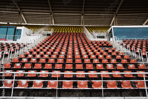 Red Empty and old plastic seats in the stadium.